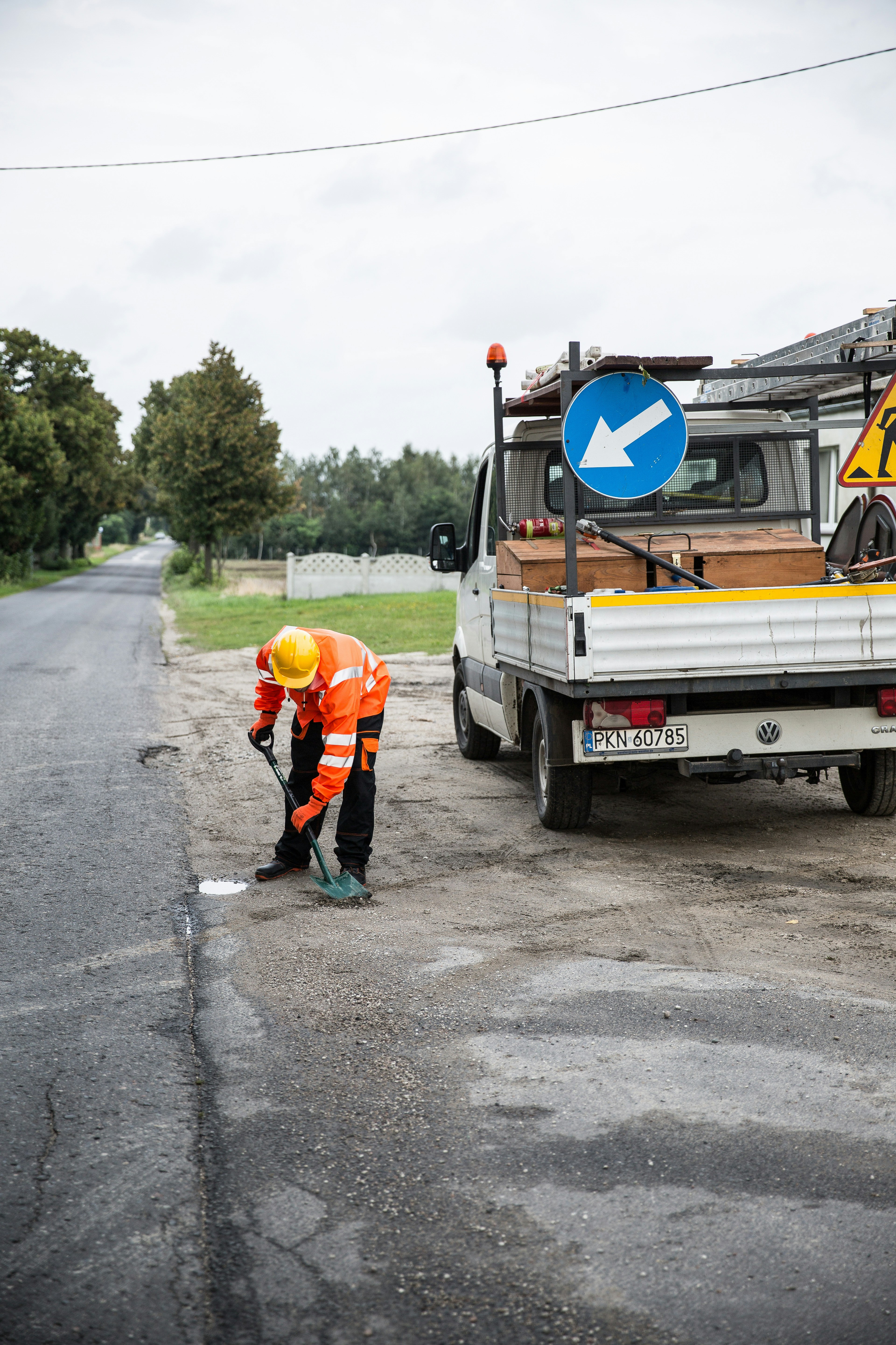 a man in an orange safety suit is working on a road