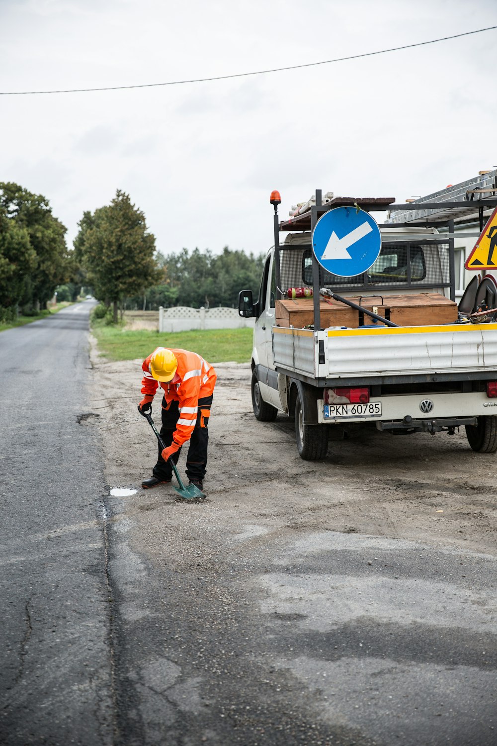 a man in an orange safety suit is working on a road