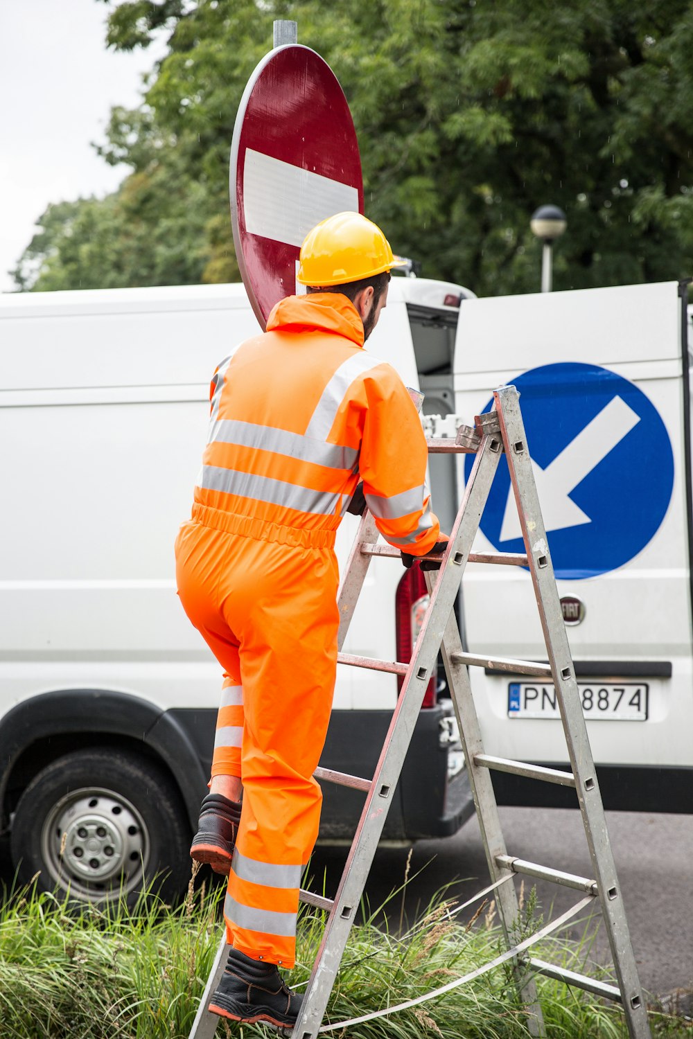 a man in an orange jumpsuit is on a ladder