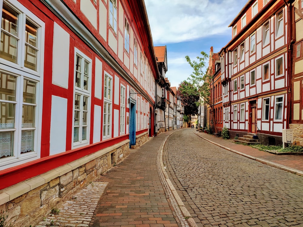 a cobblestone street lined with red and white buildings