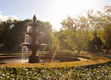 A serene water fountain surrounded by smooth stones and greenery.