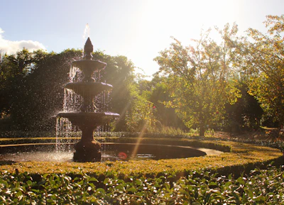 A serene water fountain surrounded by smooth stones and greenery.