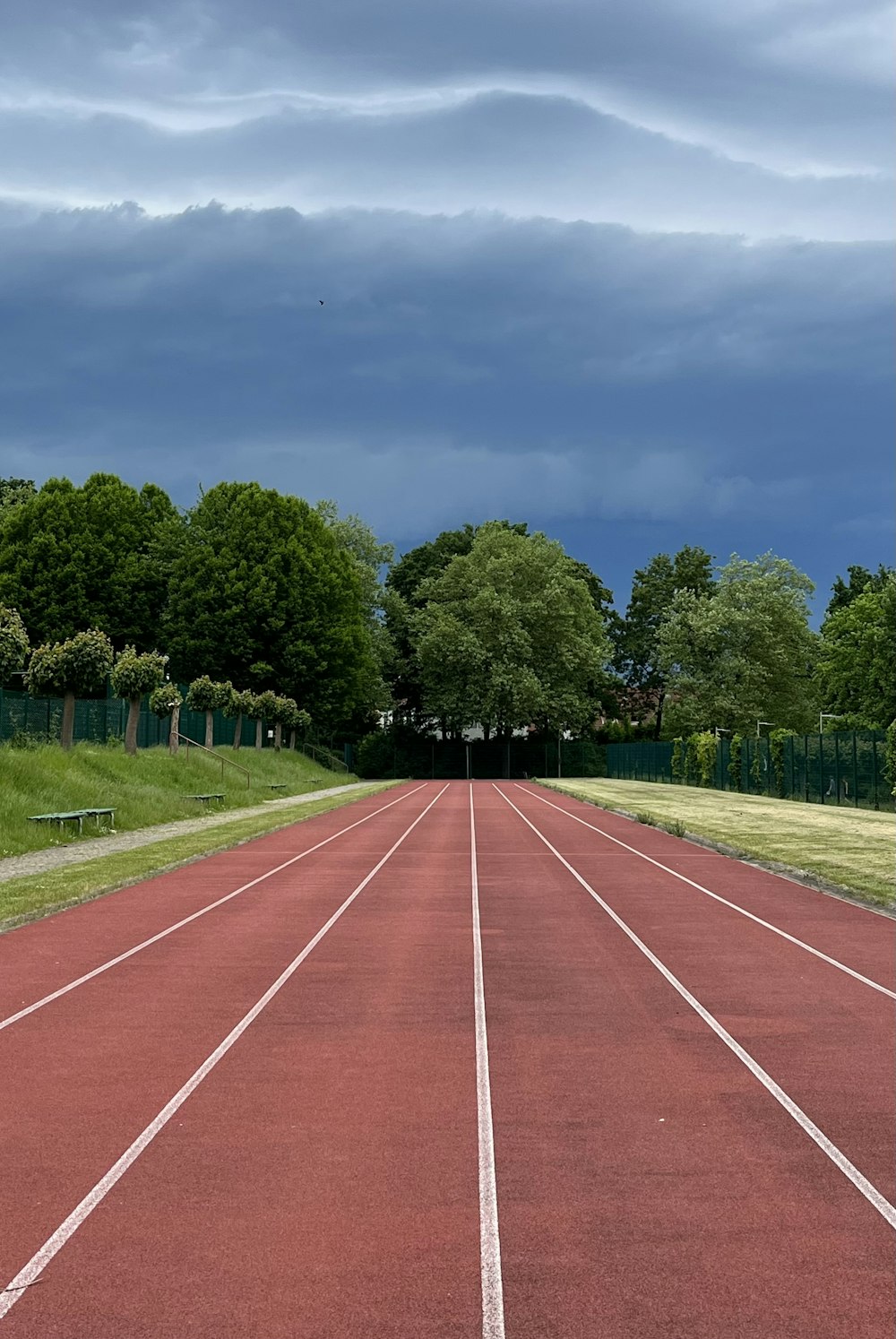 a red running track with trees in the background
