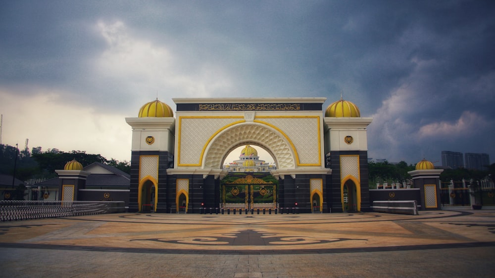a large white and yellow building with yellow domes