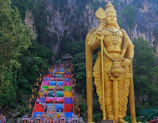 a large statue of a god in front of a mountain