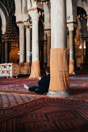 a man sitting on the floor of a large building