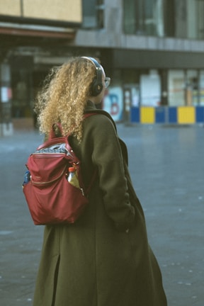 A person walking with headphones, surrounded by floating audio waveforms and map markers.