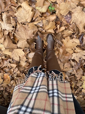 Cozy wool-lined winter boots set beside a knitted scarf and autumn leaves.