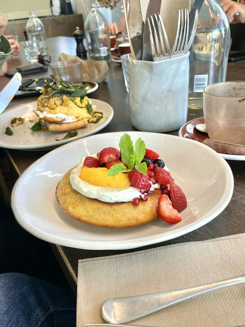 a white plate topped with a cake covered in fruit