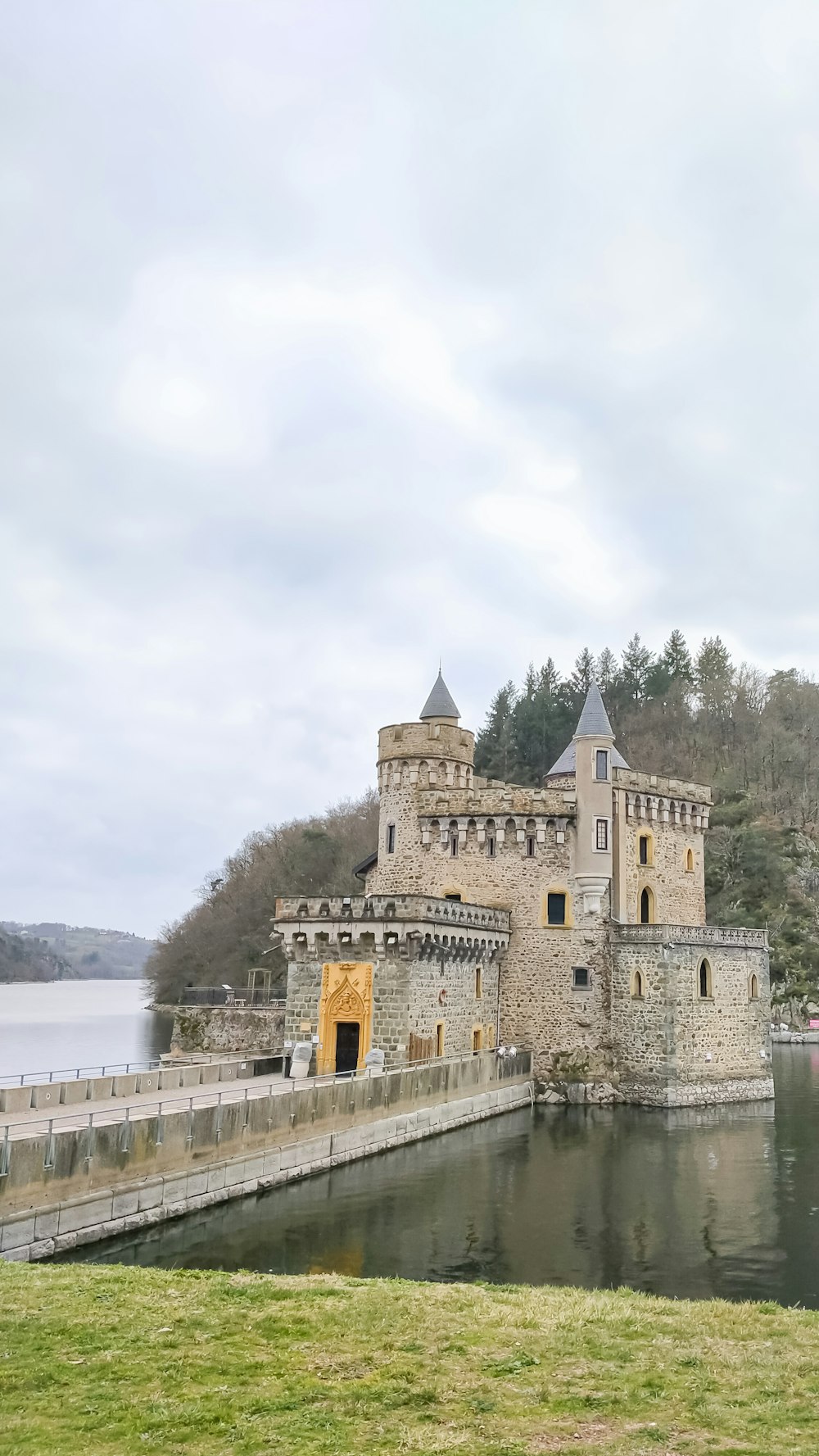 a large castle sitting on top of a lush green hillside