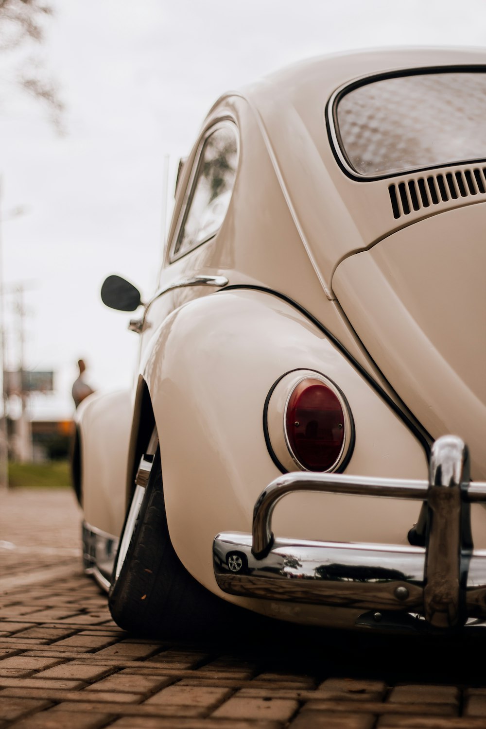 a white vw bug parked on a brick road