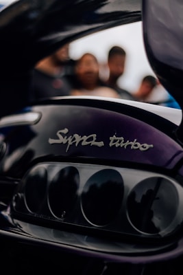 a close up of a motorcycle engine with people in the background