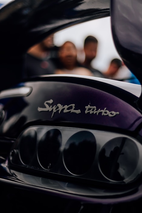 a close up of a motorcycle engine with people in the background