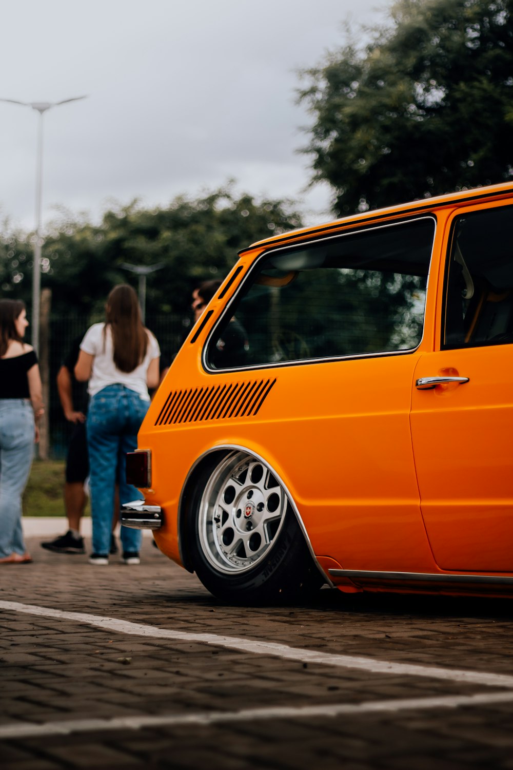 a small orange van parked in a parking lot