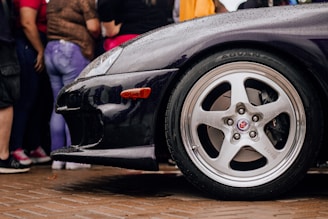 Side profile of a black SUV with shiny rims on display.