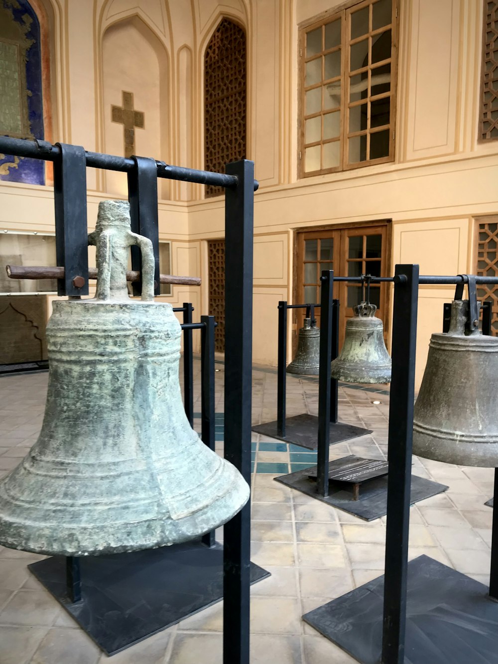 a group of bells sitting on top of a tiled floor