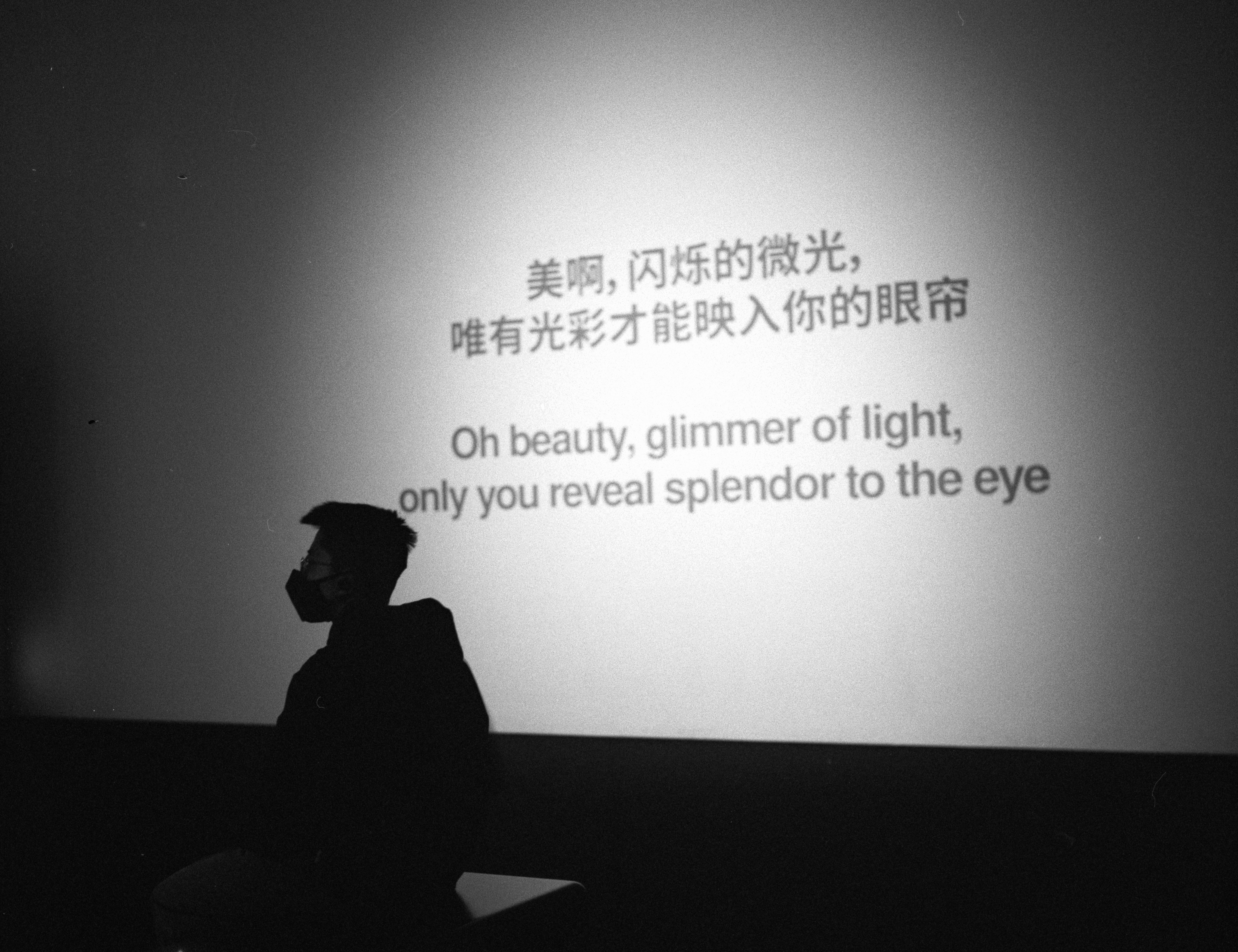 a man sitting in front of a projection on a wall