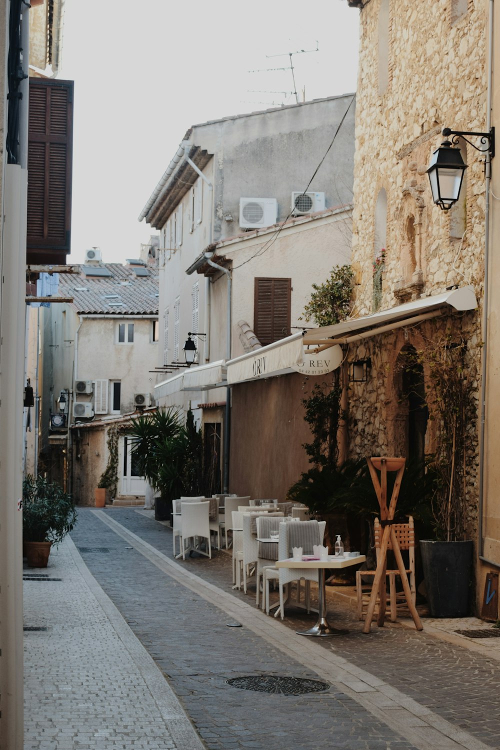 a narrow street with tables and chairs on it