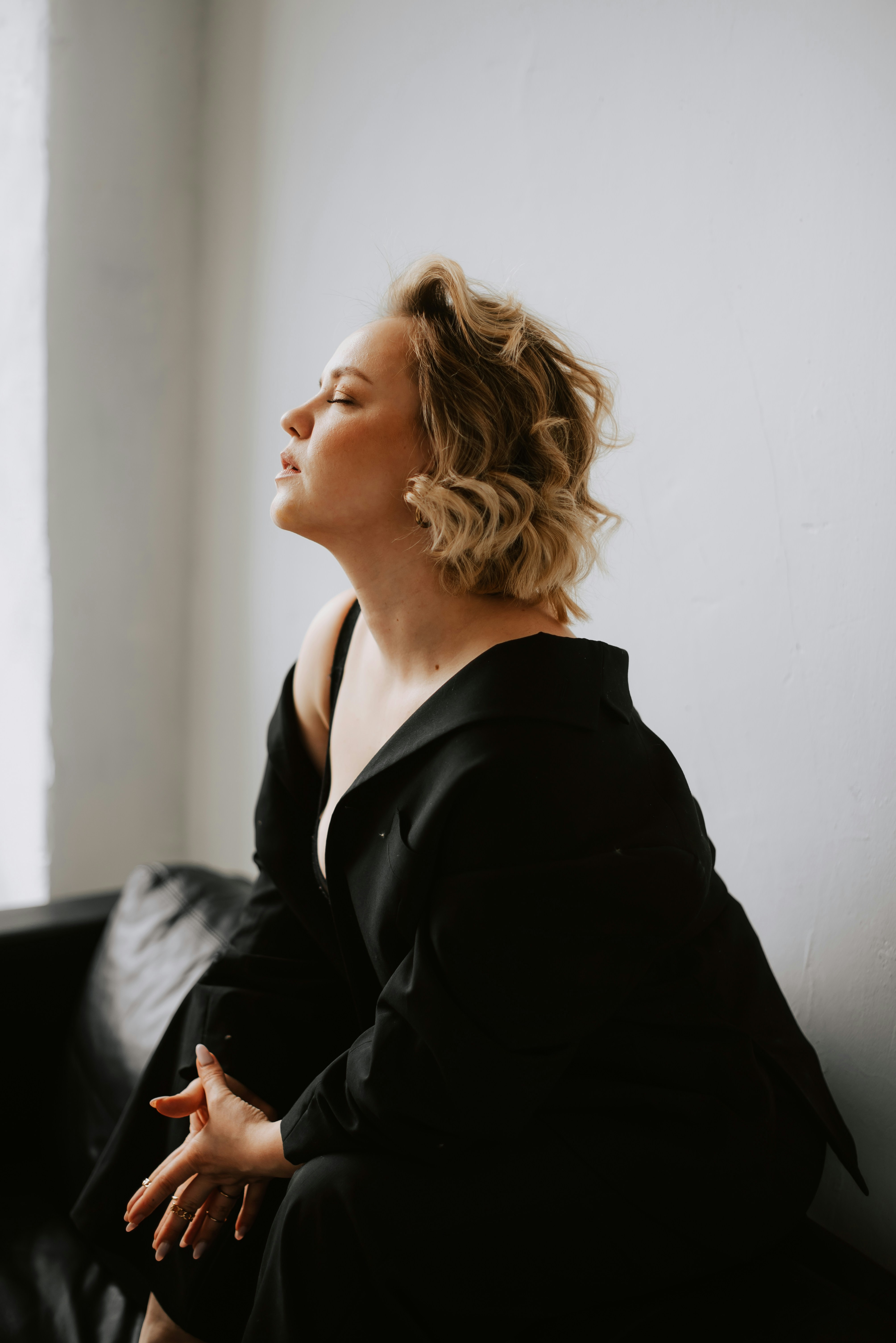 a woman in a black dress sitting on a black couch