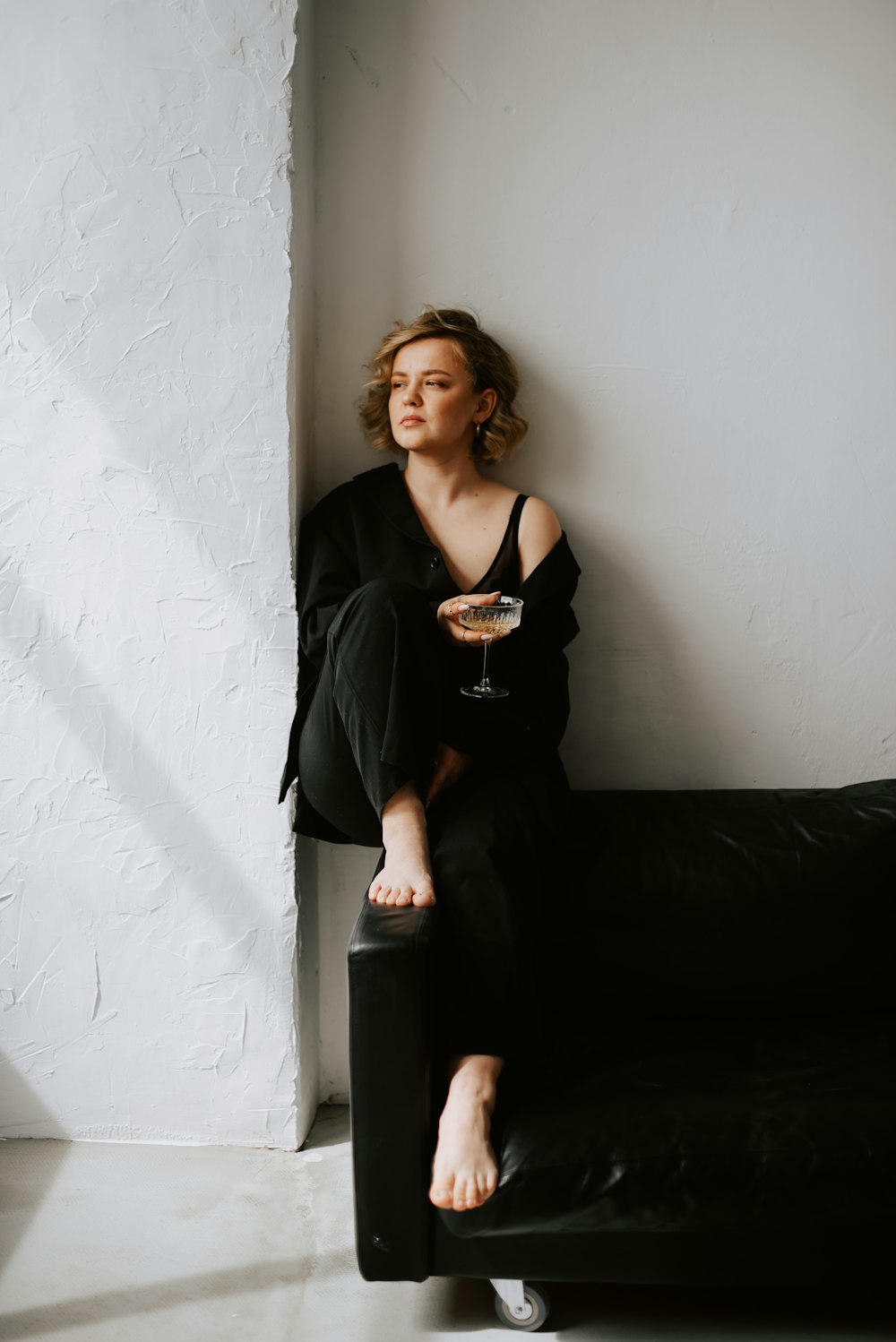 a woman sitting on a couch with a glass of wine