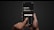 A person holding a smartphone with both hands against a dark background. The screen displays a calculator-like interface with a financial transaction and currency conversion in pounds and euros, along with fee information. A finger is pressing a button labeled 'Continue'.