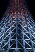 Structural steel framework illuminated with neon blue lights at night.
