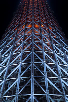 Structural steel framework illuminated with neon blue lights at night.