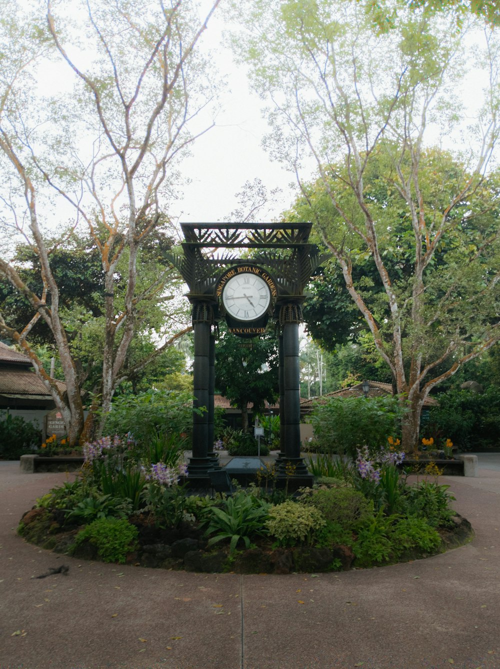 a clock sitting in the middle of a garden