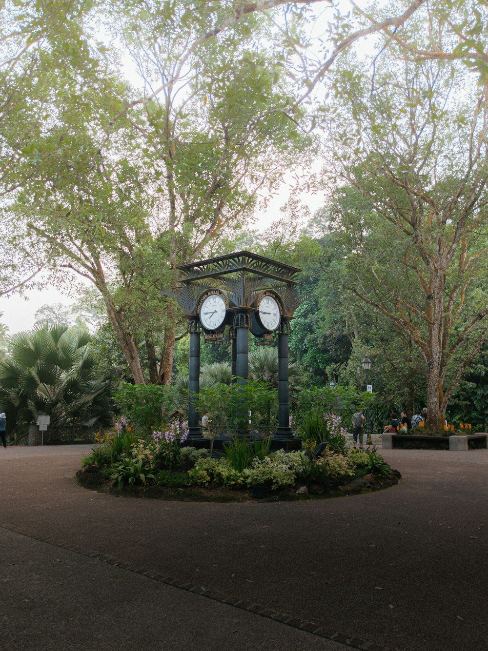 a clock tower in a park surrounded by trees