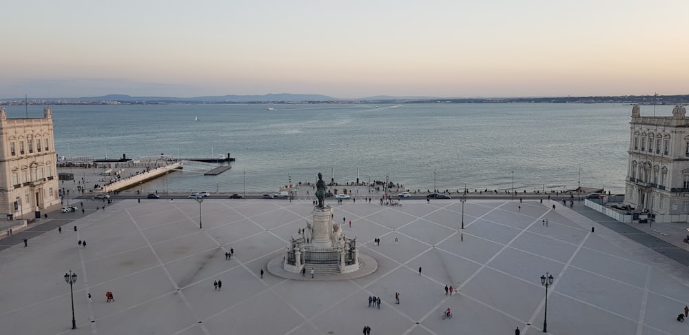 a city square with a clock tower and a body of water