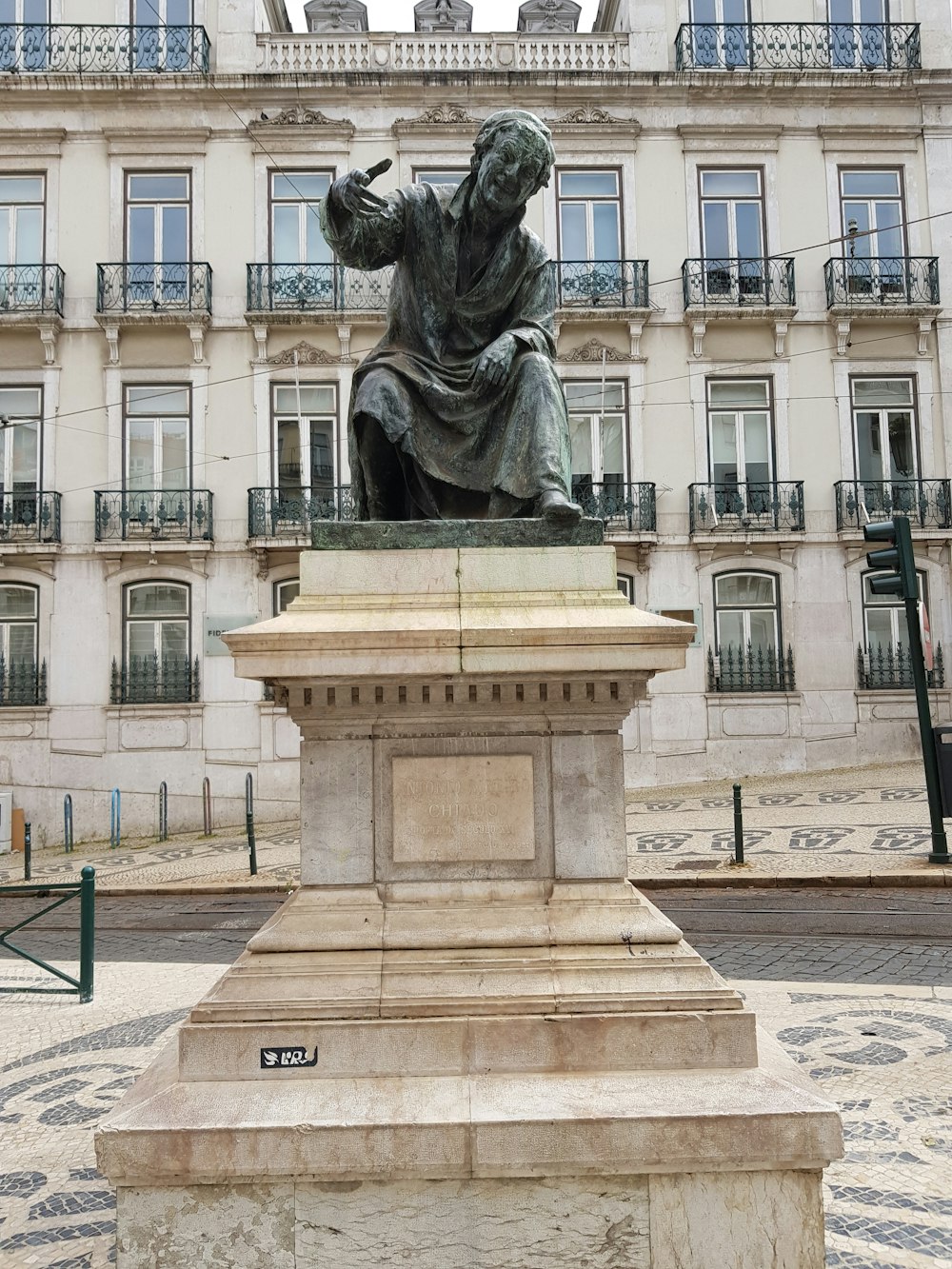 a statue of a man sitting in front of a building