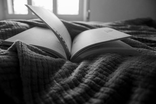 an open book sitting on top of a bed