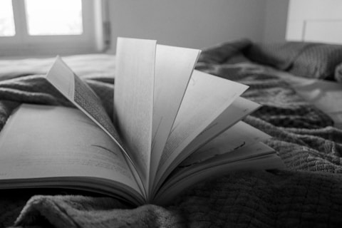 an open book sitting on top of a bed
