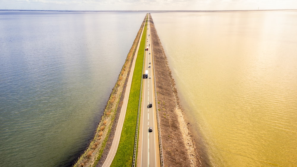 an aerial view of a long stretch of road next to a body of water