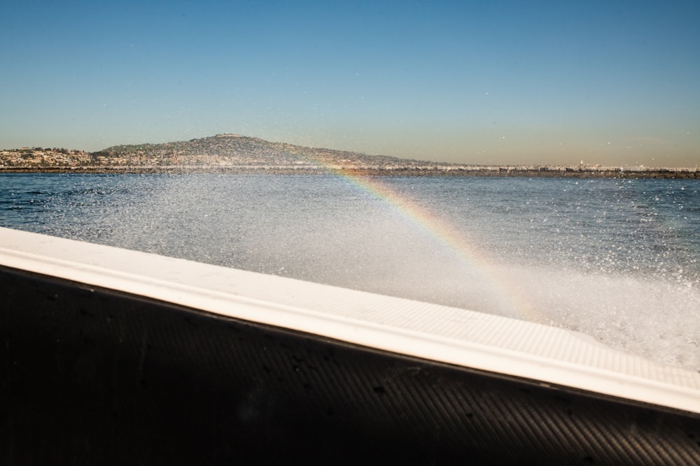 a rainbow is seen in the distance from a boat