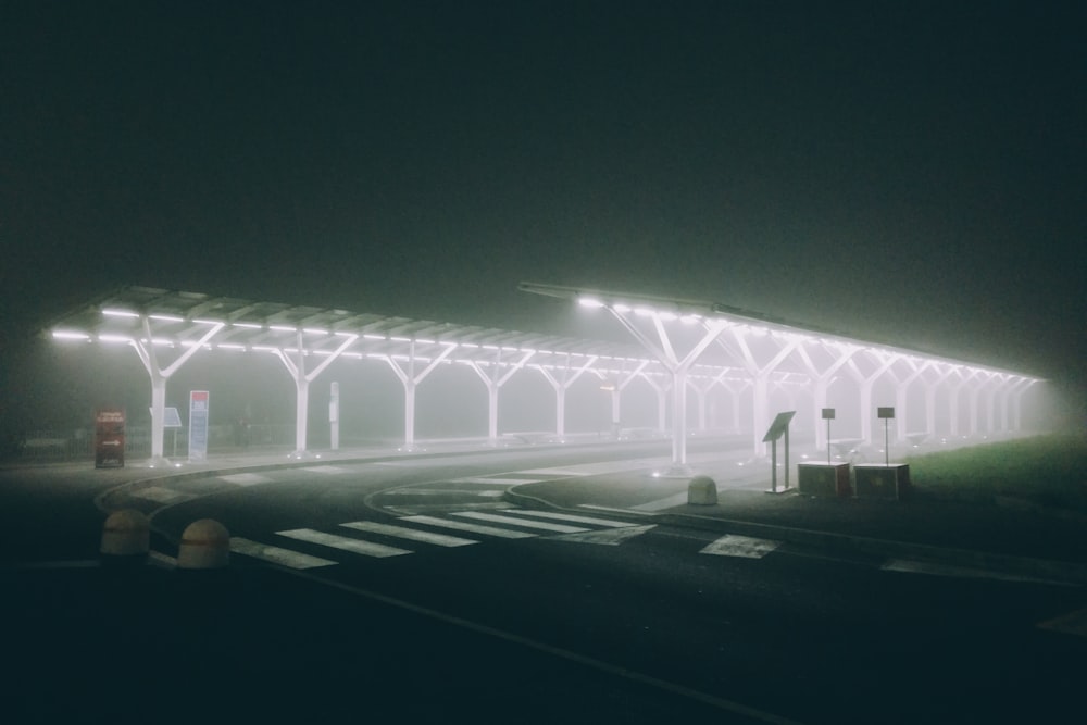 a foggy night at a bus stop with lights on