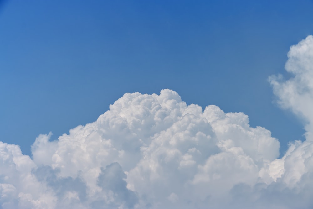 a large cloud in the sky with a blue sky background