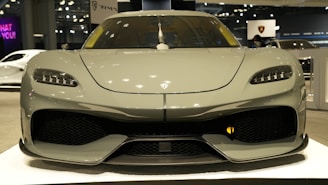 A sleek car lined up for auction under bright lights, ready for bidding.