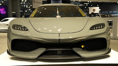 A sleek car lined up for auction under bright lights, ready for bidding.