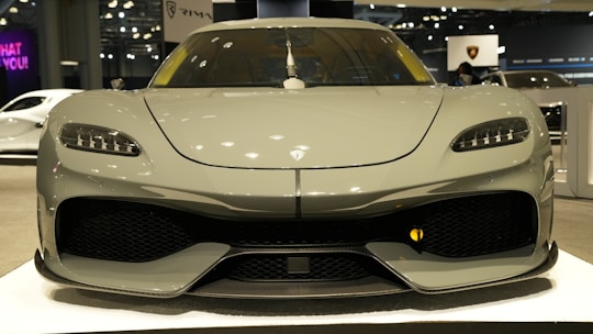 A sleek car displayed on a digital auction platform screen with bidding details.