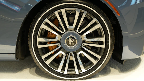 Detail of a hand polishing a luxury car’s wheel rim to a perfect shine.