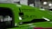 A close-up view of a vibrant green car with decals featuring the words 'Vibrant Performance' and 'Radium Engineering'. The car door window displays the text 'IS LOCKED'. The background suggests an indoor setting, possibly at a car show or exhibition.