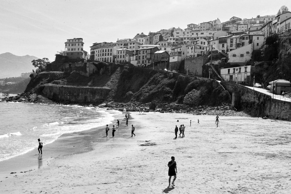 a group of people standing on top of a sandy beach