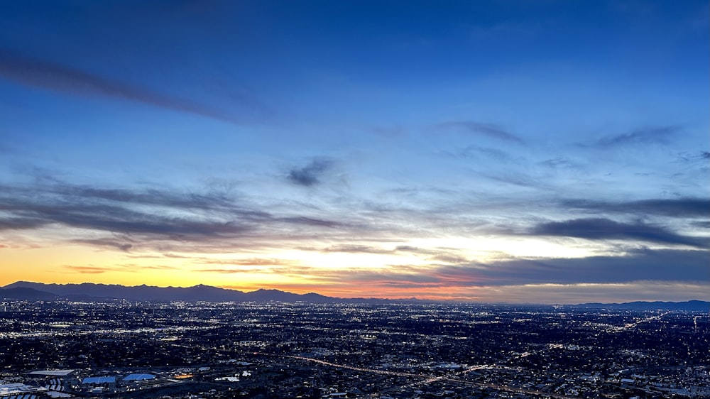 a view of a city at sunset from the top of a hill