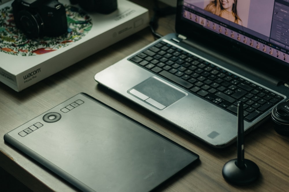 a laptop computer sitting on top of a wooden desk