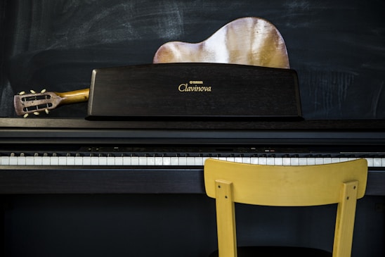 a yellow chair sitting next to a piano