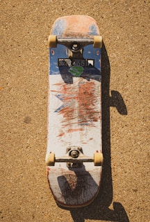 Close-up of a well-used skateboard deck with vibrant graphics.