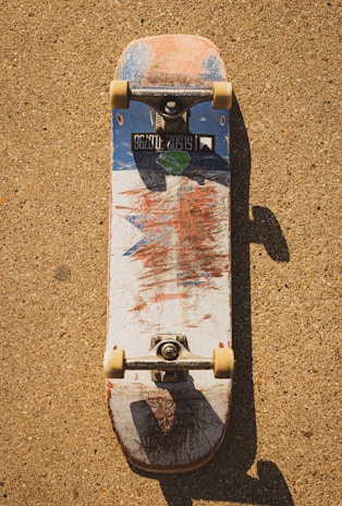 Close-up of a well-used skateboard deck with vibrant graphics.