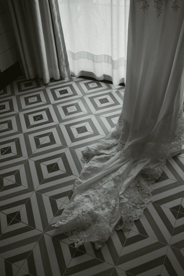 Soft ivory lace gently draped over a bride's silhouette, capturing delicate elegance in natural light.