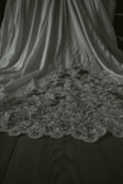 Detailed view of a textured ivory fabric draped over a dark wooden surface.